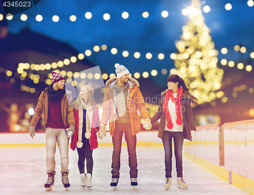 Image of happy friends at christmas skating rink