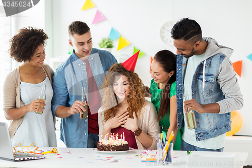 Image of team greeting colleague at office birthday party