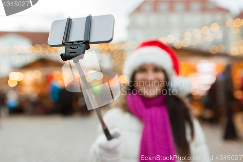 Image of woman taking selfie by smartphone at christmas 