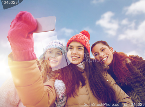 Image of happy teenage girls taking selfie with smartphone