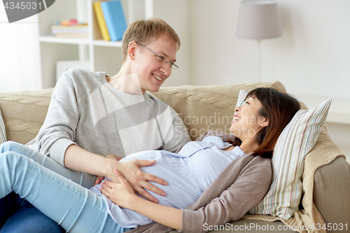 Image of happy pregnant wife with husband at home