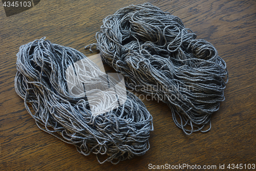 Image of coils of gray wool on a wooden table