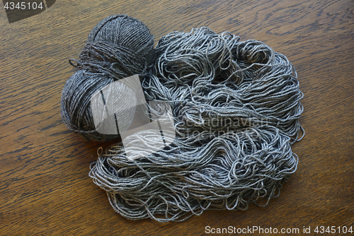 Image of coils of gray wool on a wooden surface