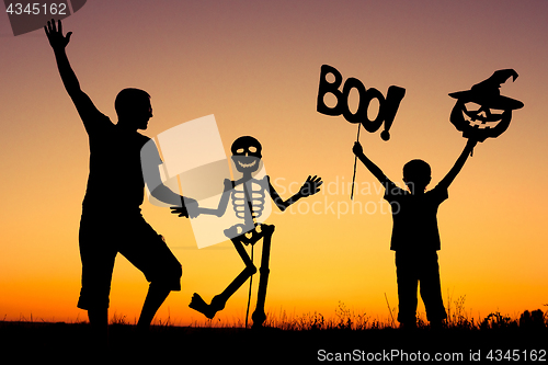 Image of Happy father and son playing outdoors at the sunset time.