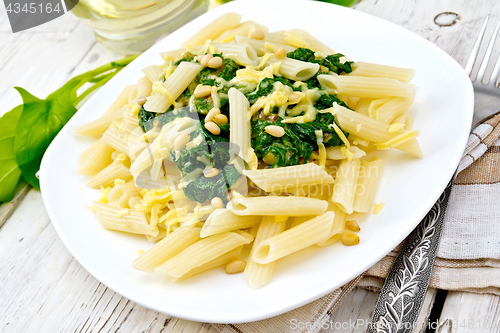 Image of Pasta penne with spinach and cedar nuts on board