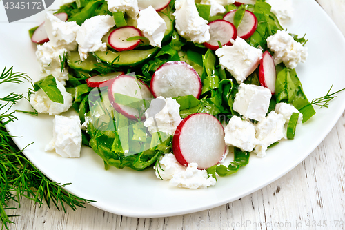 Image of Salad with spinach and cheese in plate on board
