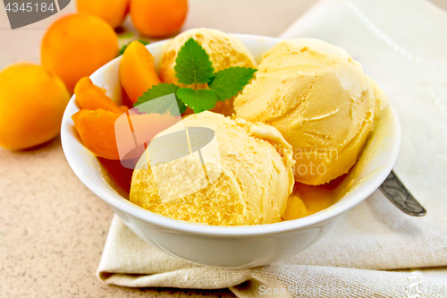 Image of Ice cream apricot in bowl with spoon on napkin