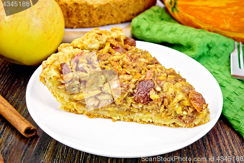 Image of Pie with pumpkin and apples in plate on board