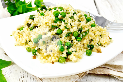 Image of Couscous with spinach in plate on napkin