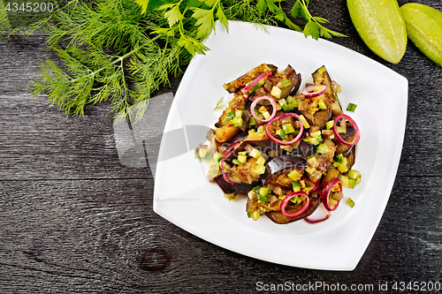 Image of Salad from eggplant and cucumber in plate on black board top