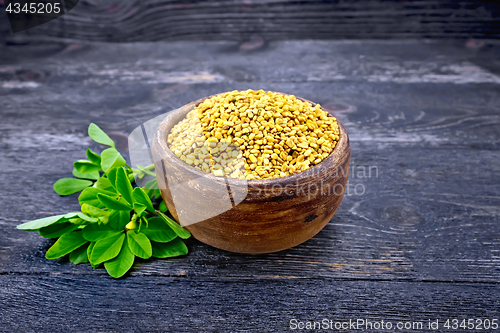 Image of Fenugreek in clay bowl with green leaf on board