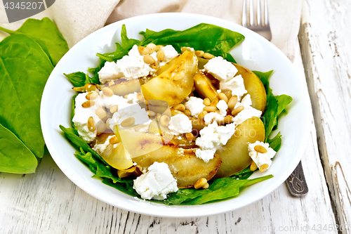 Image of Salad from pear and spinach in dish on board