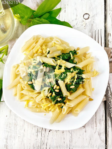 Image of Pasta penne with spinach and nuts on light board top