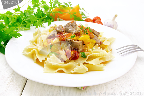 Image of Farfalle with turkey and vegetables in sauce on board