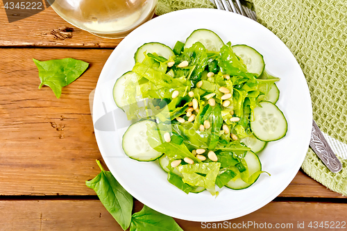 Image of Salad from spinach and cucumber with lettuce on board top