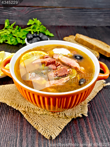 Image of Solyanka with olives in bowl on dark board