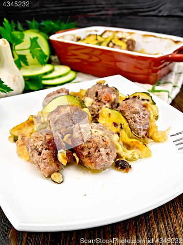 Image of Meatballs with zucchini and nuts in plate on darkt board