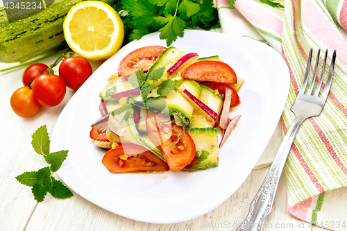 Image of Salad with zucchini and tomato in plate on light board