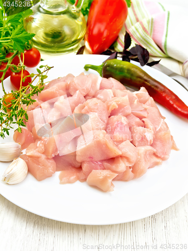 Image of Chicken breast raw sliced in plate with vegetables on light boar