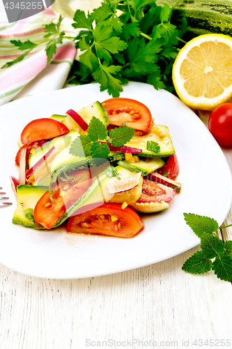 Image of Salad with zucchini and tomato in plate on board
