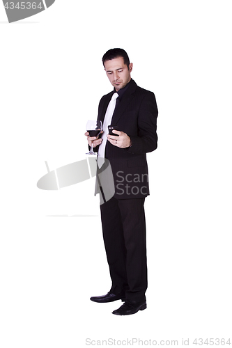 Image of Businessman  with a glass of drink texting