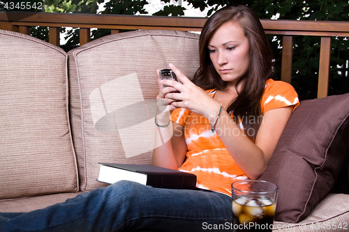 Image of Beautiful Girl  Texting in the Patio