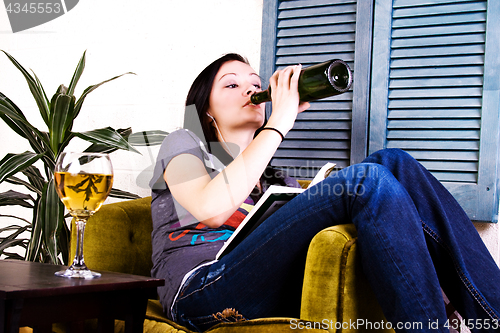 Image of Cute Girl Drinking while Reading a Book