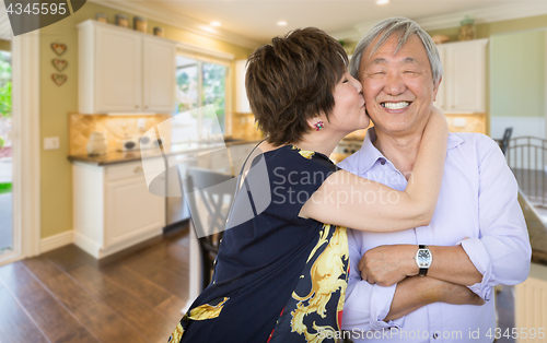 Image of Happy Senior Chinese Couple Kissing Inside Beautiful Custom Kitc