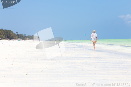 Image of Happy woman having fun, enjoying summer, running along white tropical beach.