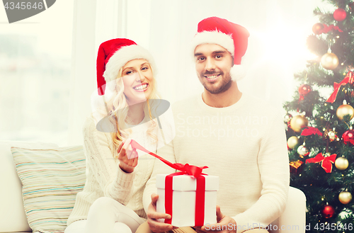 Image of happy couple at home with christmas gift box