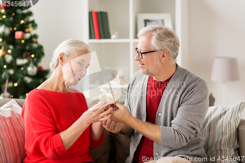 Image of happy smiling senior couple with christmas gift