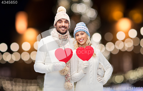 Image of couple with red hearts over christmas lights