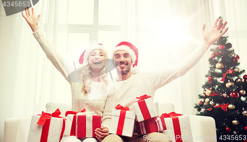 Image of happy couple at home with christmas gift boxes