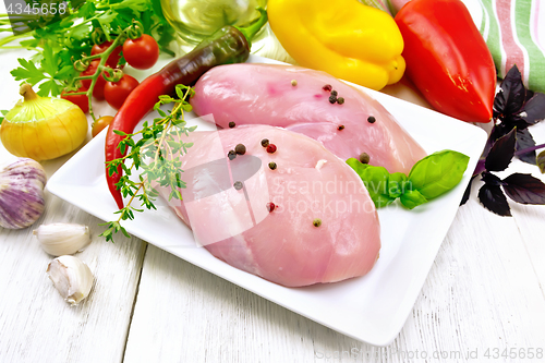 Image of Chicken breast raw in plate with vegetables and spices on table