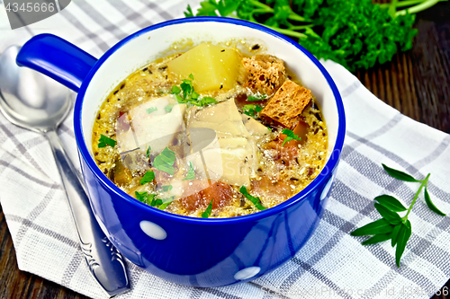 Image of Soup fish with vegetables and croutons on dark board