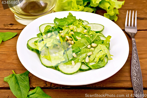 Image of Salad from spinach and cucumbers with lettuce on table