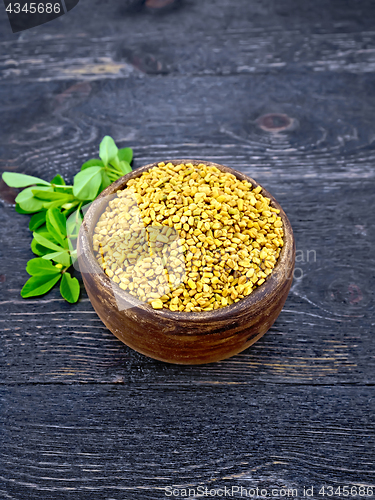 Image of Fenugreek with green leaf in clay bowl on wooden board