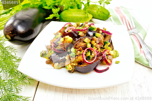 Image of Salad from eggplant and cucumber with red onion in plate on ligh