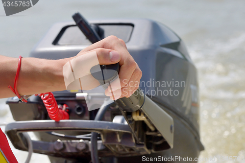 Image of Fisherman hand and boat engine