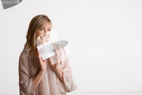 Image of Woman showing holding blank card, note, message