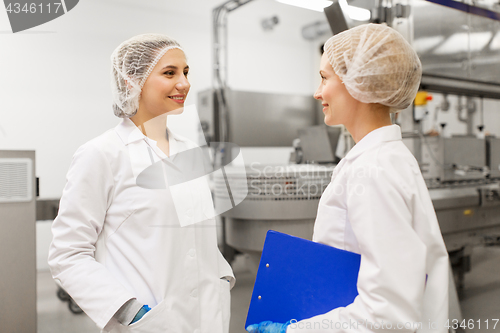 Image of happy women technologists at ice cream factory