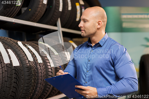 Image of auto business owner and wheel tires at car service