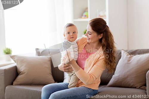 Image of happy young mother with little baby at home