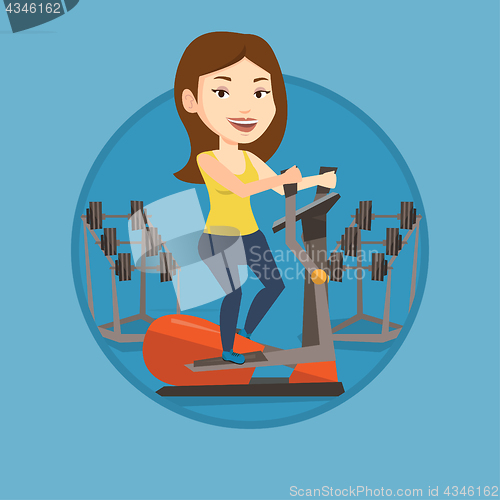 Image of Woman exercising on elliptical trainer.