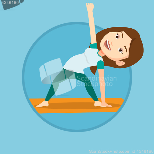 Image of Woman practicing yoga triangle pose.