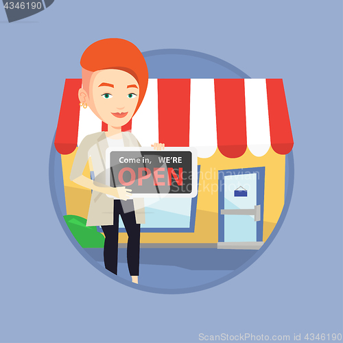 Image of Female shop owner holding open signboard.