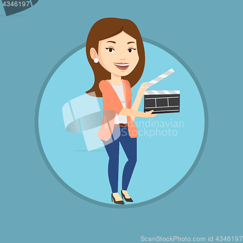 Image of Smiling woman holding an open clapperboard.