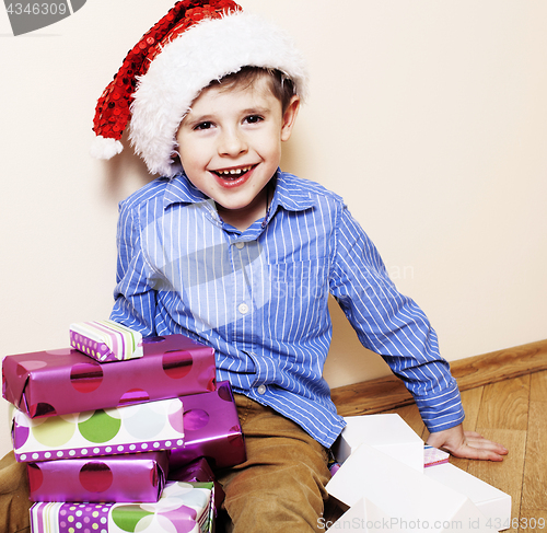 Image of little cute boy with Christmas gifts at home. close up emotional