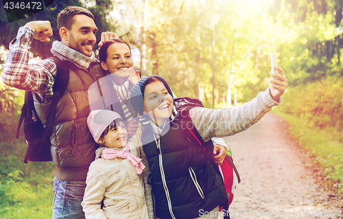 Image of family with backpacks taking selfie by smartphone