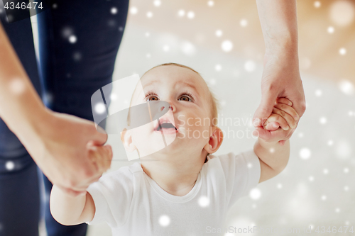 Image of happy baby learning to walk with mother help